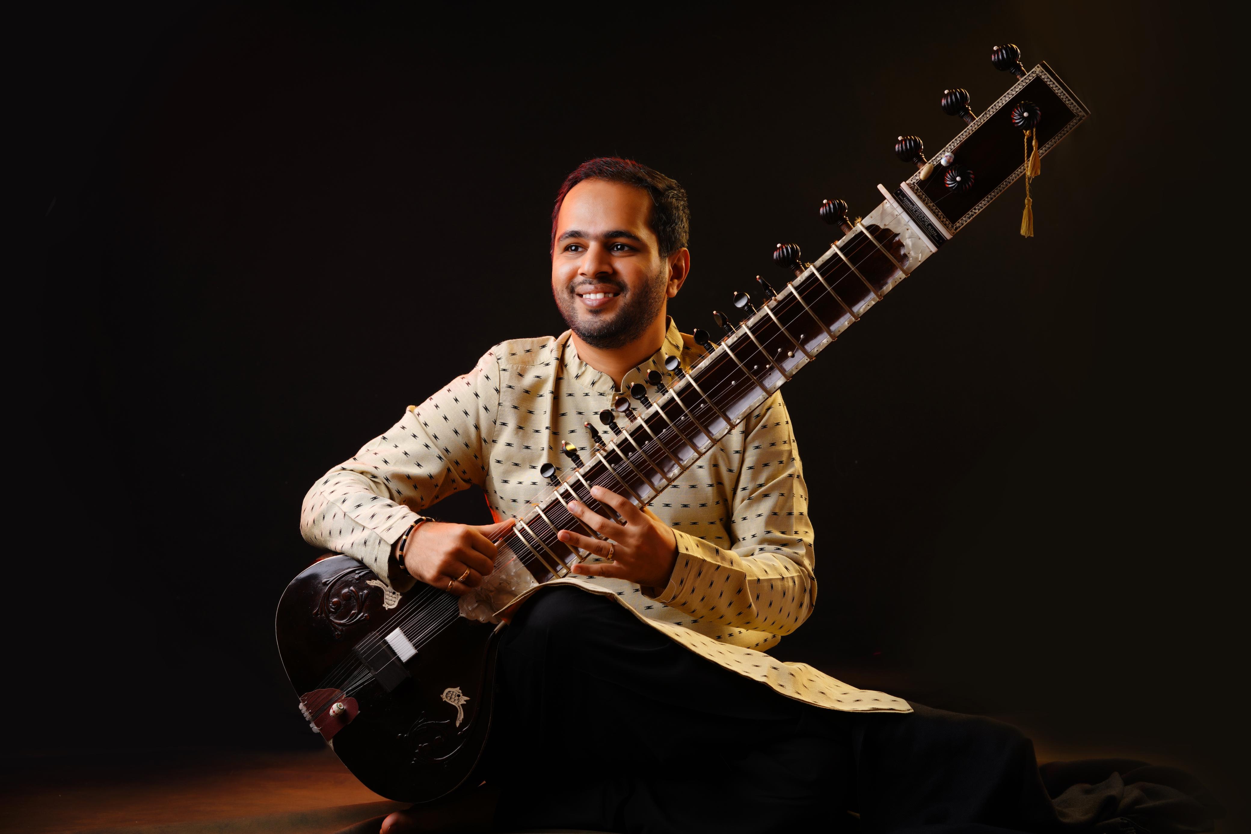Ankush N Nayak in ivory attire with sitar